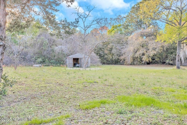 view of yard featuring a view of trees and an outdoor structure