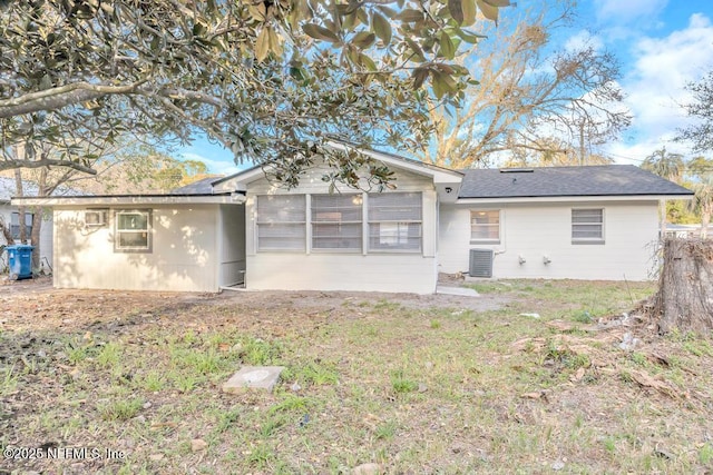 rear view of property with cooling unit and a yard