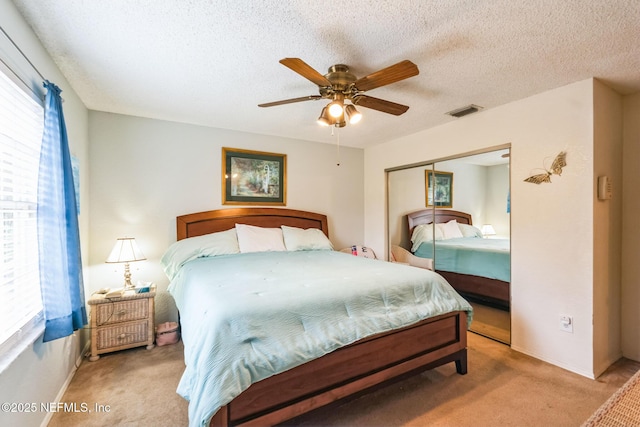 bedroom featuring a closet, visible vents, multiple windows, and carpet