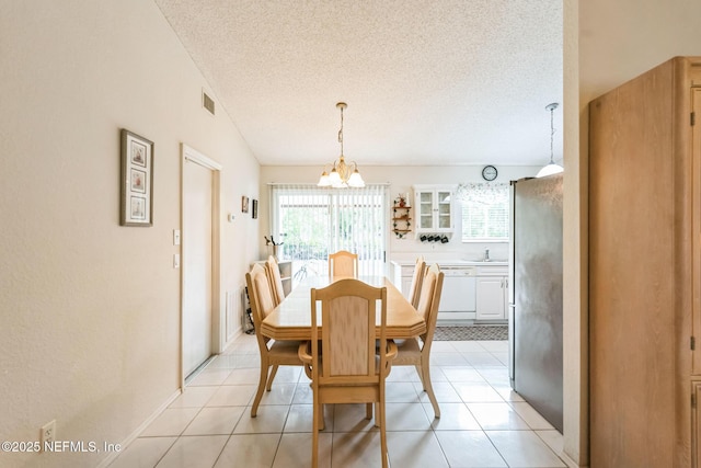 dining space with visible vents, a textured ceiling, light tile patterned flooring, and a notable chandelier