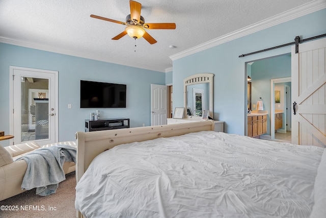 bedroom featuring a ceiling fan, ornamental molding, ensuite bathroom, a textured ceiling, and a barn door