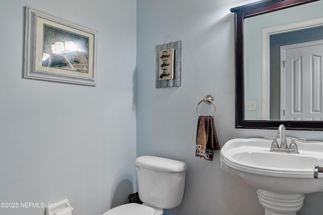 half bathroom featuring a sink and toilet