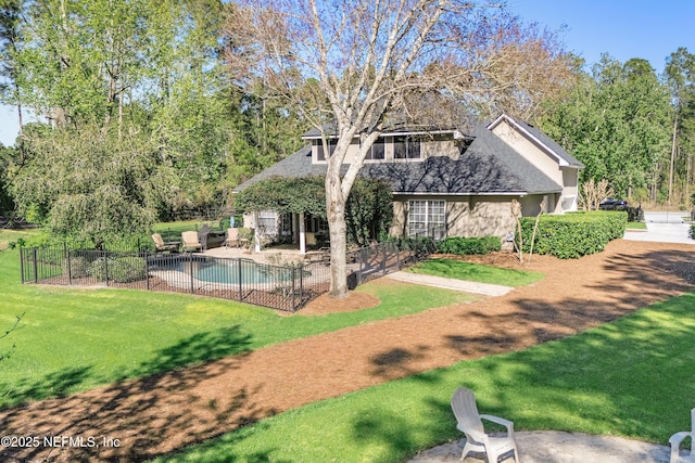 back of property with a yard, fence, a fenced in pool, and a patio area