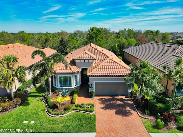 view of front of home featuring a tiled roof, decorative driveway, a garage, and stucco siding