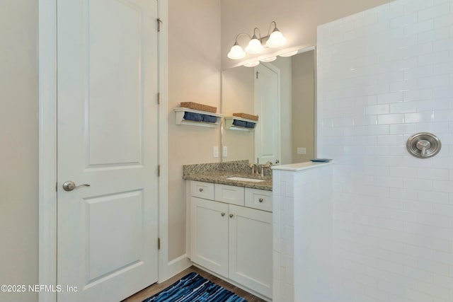 bathroom with vanity and a tile shower