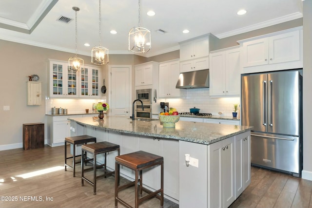 kitchen with white cabinets, visible vents, under cabinet range hood, and stainless steel appliances