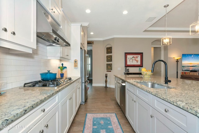 kitchen with visible vents, under cabinet range hood, appliances with stainless steel finishes, arched walkways, and a sink