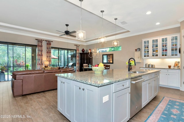 kitchen featuring open floor plan, light wood-type flooring, white cabinetry, a raised ceiling, and a sink