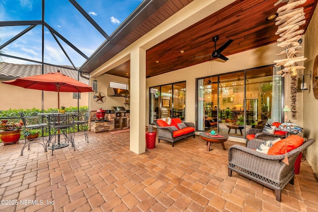 view of patio with a ceiling fan, area for grilling, outdoor dining area, a lanai, and an outdoor hangout area