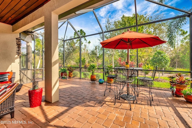 view of patio / terrace with outdoor dining space and a lanai