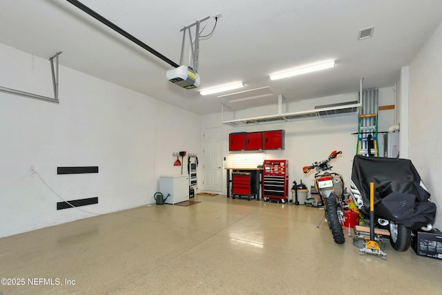 garage featuring a garage door opener and visible vents