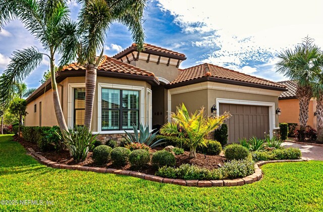 mediterranean / spanish-style house with a garage, stone siding, a front yard, and stucco siding