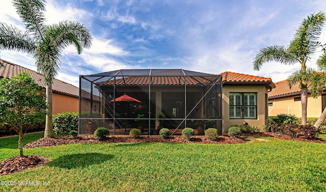 rear view of house featuring a lanai, a lawn, a tile roof, and stucco siding