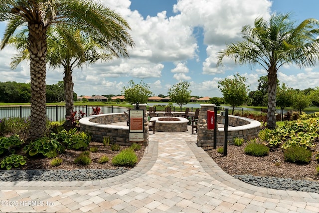 view of property's community featuring a fire pit and fence