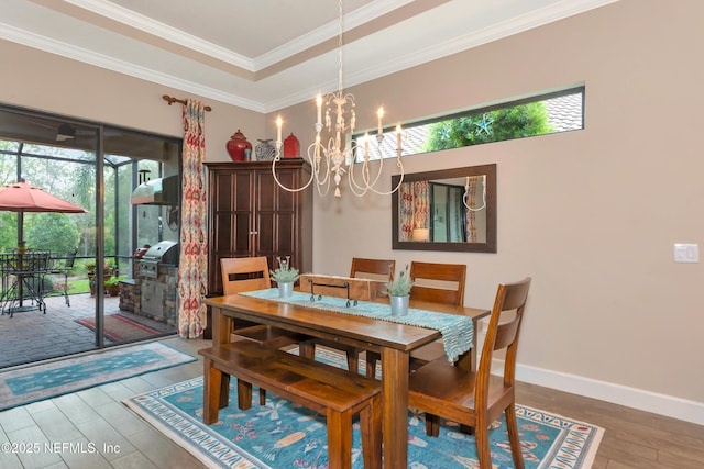 10030 Craftsman Park Way, Palmetto, FL 34221 - dining space featuring plenty of natural light, wood finished floors, a chandelier, ornamental molding, and baseboards