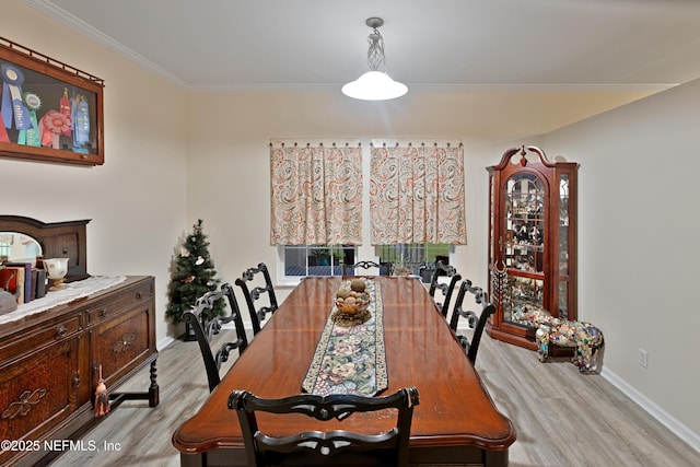 dining space with crown molding, light wood-type flooring, and baseboards