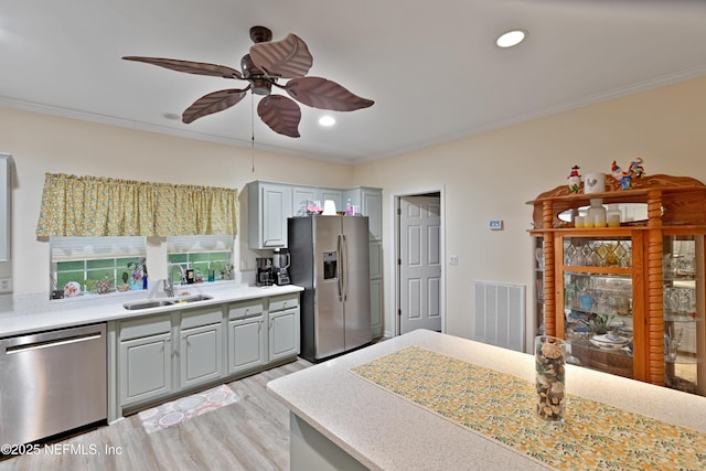 kitchen featuring a sink, visible vents, appliances with stainless steel finishes, and crown molding