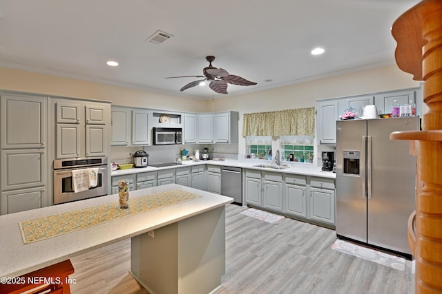 kitchen with a sink, visible vents, appliances with stainless steel finishes, and crown molding