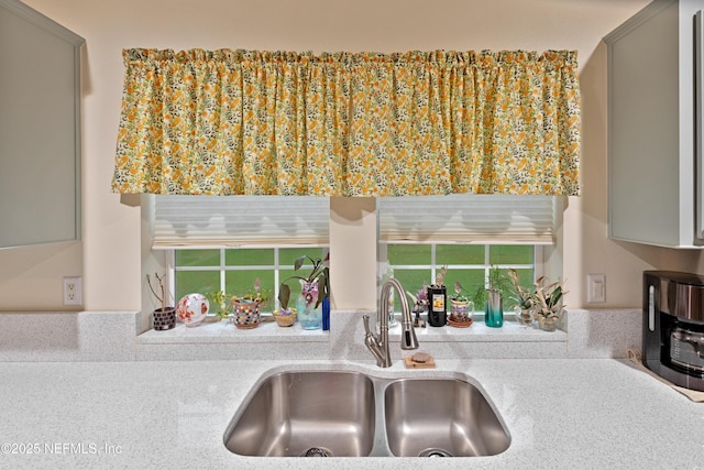 room details featuring a sink, gray cabinets, and light countertops