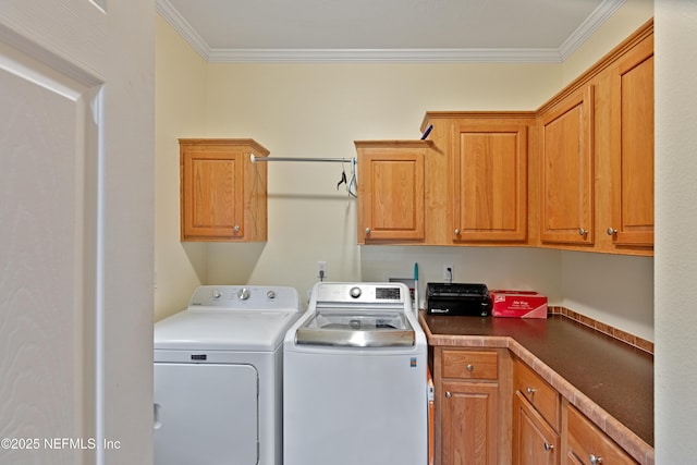 clothes washing area featuring washing machine and dryer, cabinet space, and ornamental molding