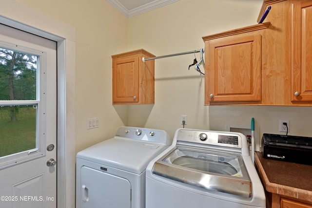 clothes washing area featuring washing machine and clothes dryer, cabinet space, and crown molding