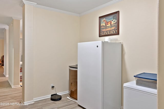 clothes washing area with baseboards, light wood finished floors, and ornamental molding