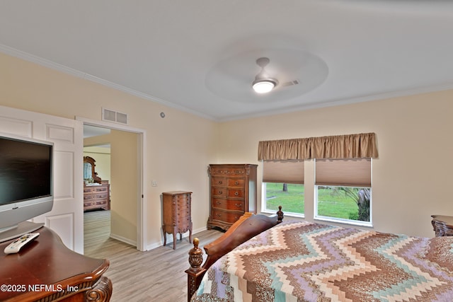 bedroom featuring light wood-type flooring, baseboards, visible vents, and ornamental molding