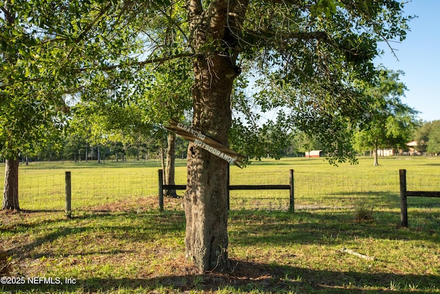 view of yard featuring a rural view and fence