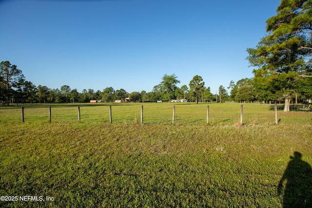 view of yard with a rural view and fence