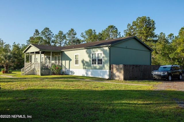 manufactured / mobile home featuring a front lawn, covered porch, and driveway