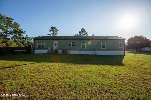 view of front facade featuring entry steps, a front lawn, and fence