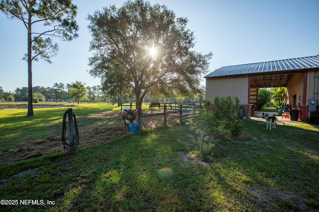 view of yard featuring an outbuilding, fence, and an outdoor structure