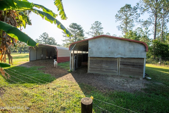 view of outdoor structure with a carport, an outdoor structure, and driveway