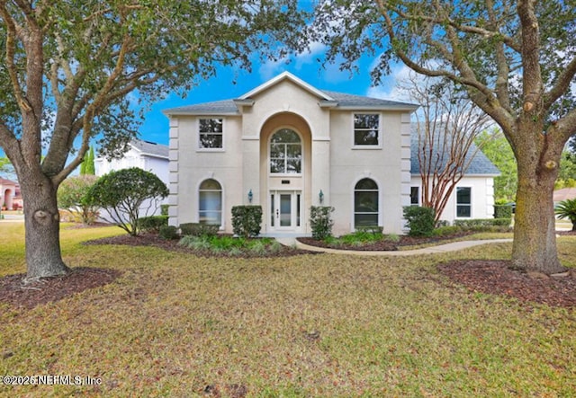 view of front of property featuring a front lawn and stucco siding