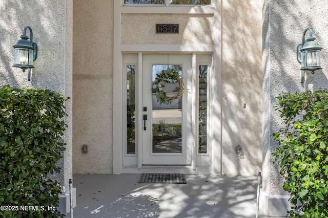 property entrance with stucco siding