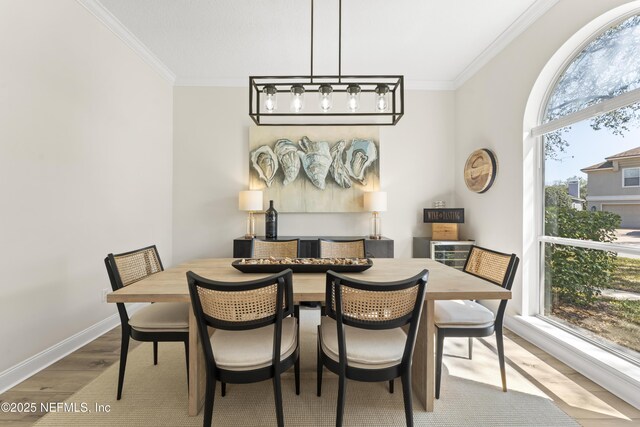 dining room featuring baseboards, wood finished floors, and crown molding