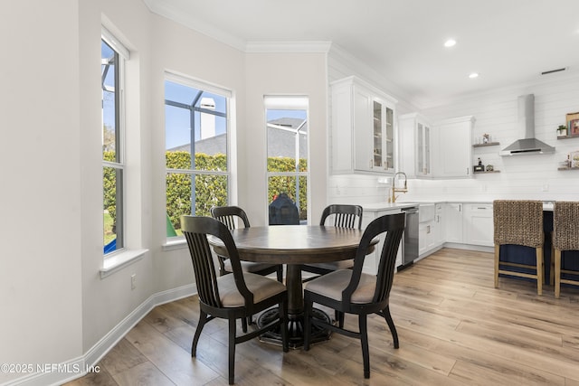 dining room featuring crown molding, recessed lighting, baseboards, and light wood-type flooring