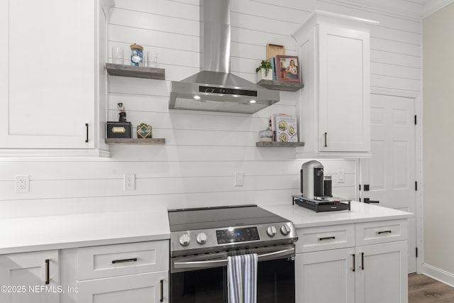 kitchen with open shelves, stainless steel range with electric cooktop, wall chimney exhaust hood, white cabinets, and light countertops