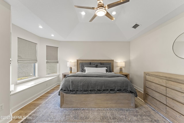 bedroom featuring a ceiling fan, visible vents, wood finished floors, baseboards, and recessed lighting