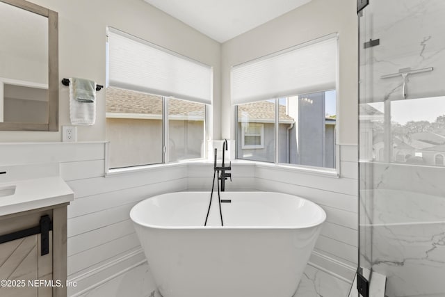 full bathroom with marble finish floor, a marble finish shower, and a freestanding bath