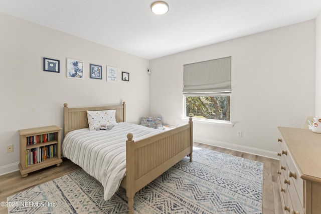 bedroom with light wood-type flooring and baseboards