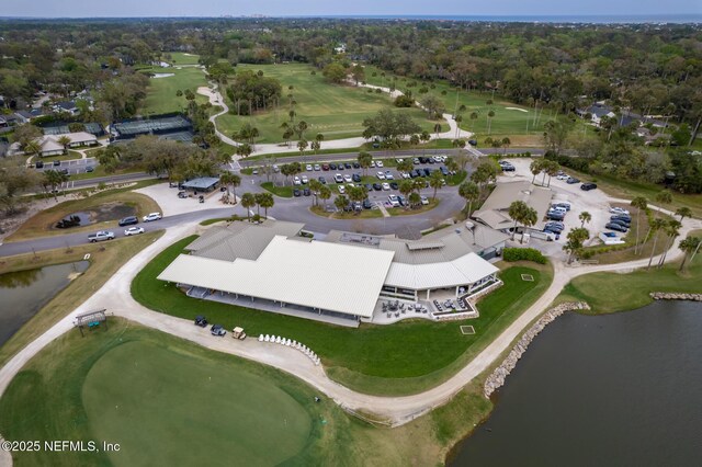 drone / aerial view featuring golf course view and a water view