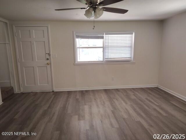 spare room with a ceiling fan, baseboards, and wood finished floors