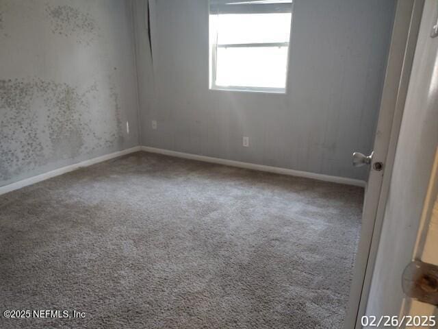 carpeted empty room with baseboards