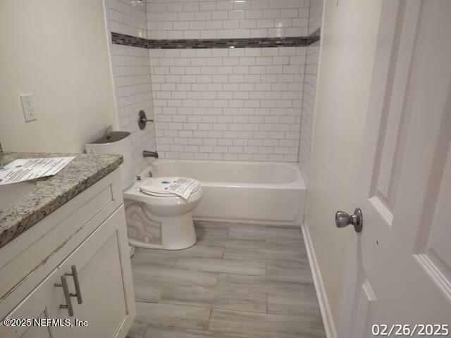 full bathroom with shower / washtub combination, toilet, vanity, and baseboards