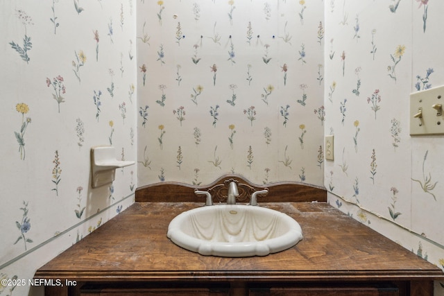 bathroom featuring wallpapered walls and a sink