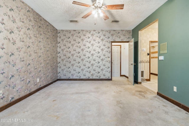 unfurnished room featuring visible vents, a textured ceiling, wallpapered walls, and carpet floors