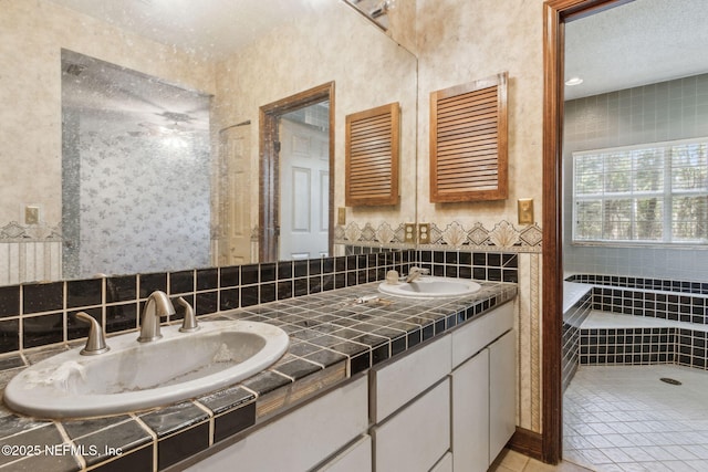 bathroom featuring a sink, backsplash, double vanity, and tile patterned floors