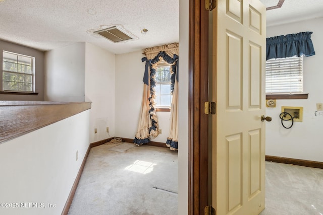 interior space featuring visible vents, carpet, baseboards, and a textured ceiling