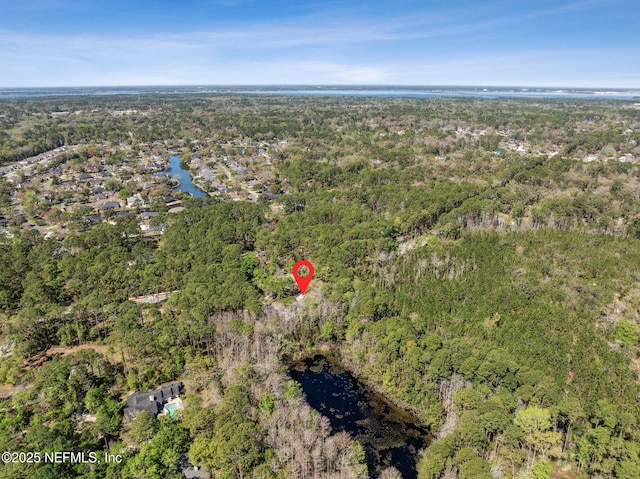 drone / aerial view with a forest view and a water view